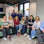 group of CNO fellows and BRC interns sitting on a sofa, with senior nurses standing behind